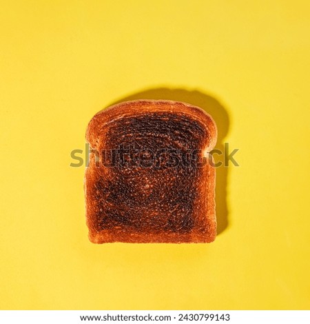 Square bread slice, burned toast isolated on the yellow background