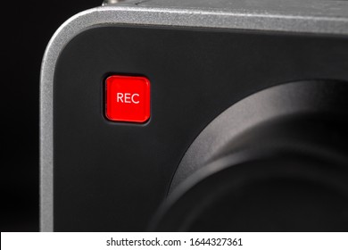 square bright red record button on gray camera body close-up