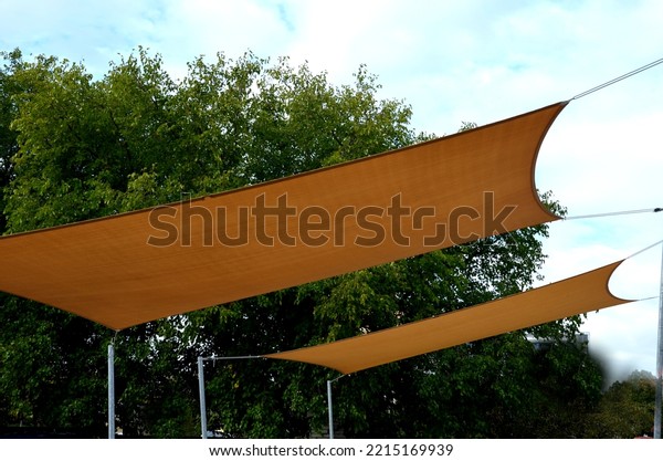 square canvas stretched, shading from sun and\
rain over terrace ofrestaurant, on playground in kindergarten, on\
platform of the promenade. pergola with metallic gray beams ,\
cable, electric, bulb,\
led