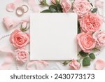 Square card near light pink roses and buds, wedding rings and silk ribbons on white table top view,  mockup. Romantic flat lay with blank card and pastel decor 