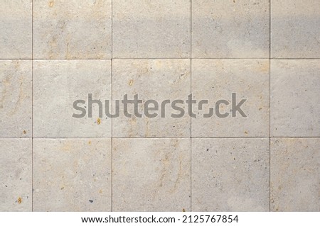 Square ceramic tile in light beige color, matt. Wall tile texture, stone
