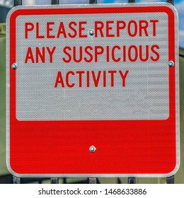 Square Close Up Of A Sign That Reads Please Report Any Suspicious Activity