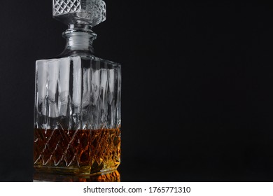 The Square Decanter Of Whiskey On A Black Background.