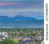 Square Dramatic sunset with clouds Panoramic view of Salt Lake City residential area in Utah. Top view of residential buildings and trees against the breathtaking mountain view and dawn sky