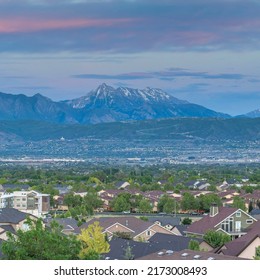 Square Dramatic sunset with clouds Panoramic view of Salt Lake City residential area in Utah. Top view of residential buildings and trees against the breathtaking mountain view and dawn sky