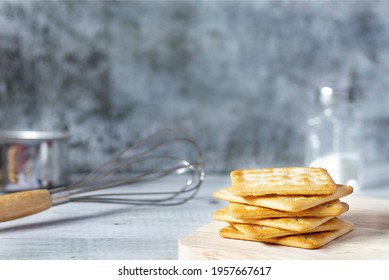 square dry crackers on a wooden table. concrete texture background. Snack dry Biscuits healthy whole wheat tasty crispy crackers cookies for children and adults have Free space for text, front view