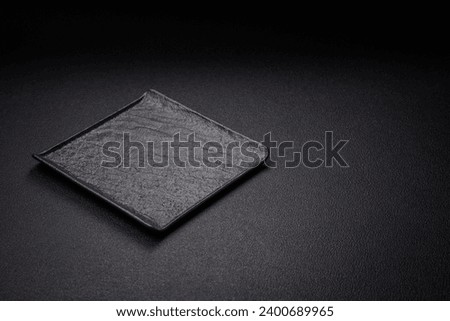 Square empty ceramic plate on textured concrete background. Kitchen utensil item