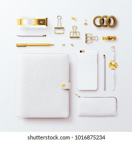 Square Flatlay Scene, With Closed White Organizer, Iphone And Gold Feminine Stationery Accessories. Arranged In A Grid On A Plain White Background.