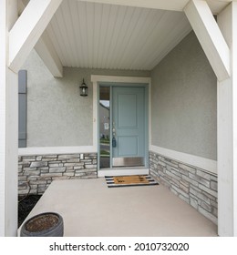 Square Frame Front Porch With Light Gray Door With Side Window Glass Panel, Doormat And Stone Bricks Wall