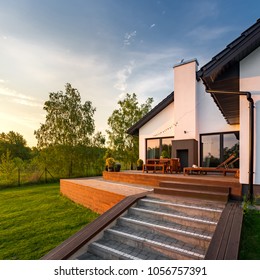 Square Frame Of White House With Wooden Patio With Steps And Green Backyard