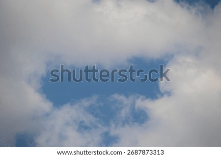 A square gap in the clouds resembles the opening of a letterbox 