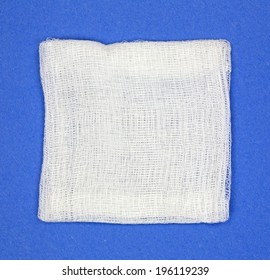 A Square Gauze Pad On A Bright Blue Background.