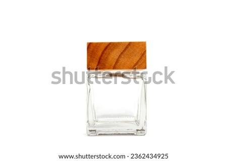 Square glass bottle with wooden lid isolate on white background with clipping path. small clear glass bottle.Glass containers for holding liquids.