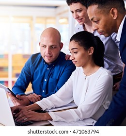 Square Image Of Four Multiethnic Diverse Business People All With Their Own Fresh Perspective On The Information That Everyone Is Looking At On The Laptop Computer And Electronic Tablet.