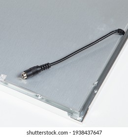 Square LED ceiling panel in metal housing on white background.