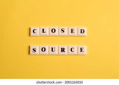 Square letters with text CLOSED SOURCE isolated on yellow background