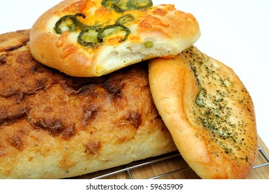 A Square Loaf Of Artisan Bread And Focaccia Rolls Including Italian Herb And Jalapeno Cheddar Cheese