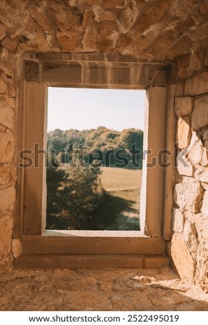 A square open window in a Castle Bobolice looking over green fields in the valley in the south of Poland. Tourism. High quality photo