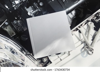 Square Owner's Manual Book On A Car Engine Mockup.