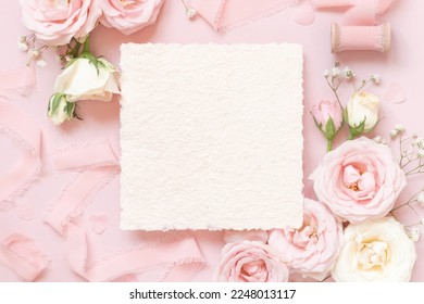 Square Paper card between light pink roses and silk ribbons on pink top view,  wedding mockup. Romantic scene with vertical blank card and pastel flowers flat lay. Valentines, Spring or Mothers day  - Shutterstock ID 2248013117