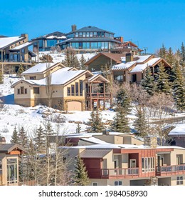 Square Park City Utah On A Winter Scene With Homes Nestled On A Snow Covered Mountain. Clear View Sky And Lush Evergreens Can Be Seen On This Picturesque Landscape.