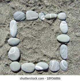 square pebble frame lying on a sand
