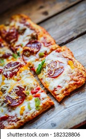 Square Pepperoni Pizza On Rustic Wooden Background