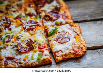 Square Pepperoni Pizza On Rustic Wooden Background