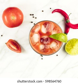 A Square Photo Of A Bloody Mary Cocktail, Shot From Above On A White Marble Texture, With Red Hot Chili Peppers, Slices Of Lime, Tomatoes, And Copyspace