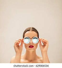 Square Portrait Of Young Woman With Sunglasses Against Beige Background. Caucasian Female Fashion Model Posing With Glasses.