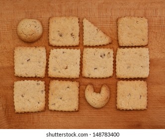 Square and round shaped ginger cookies stacked on wooden board - Shutterstock ID 148783400