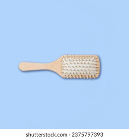 Square shot of wooden massage hairbrush isolated on blue background. Clipping Path. Full depth of field.
