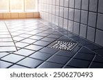 Square shower drain new and clean in tiled floor of modern enclosure in bathroom. New restroom tile floor clean and dry in house.