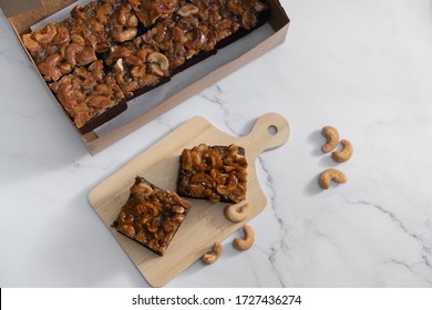 The Square Slice Of Toffee Cake With Cashew Nut
And Caramel Syrup On Marble Background. 