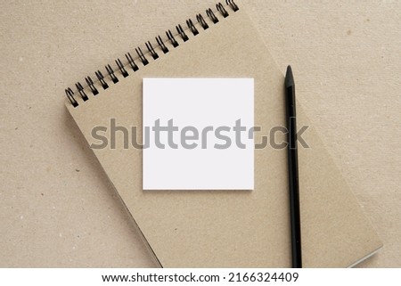 Square small notepad mockup for text or design presentation, sticky notes mock up, composition with kraft paper notebook and pencil.
