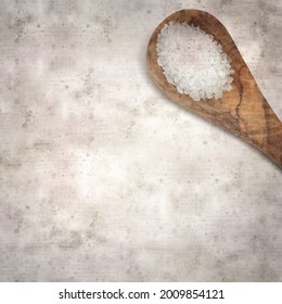 square stylish old textured paper background with a wooden spoon full of seasalt