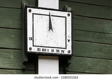 Square Vintage Sundial Placed On A Green Wooden Wall