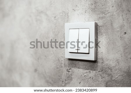 Square white switch with two keys to control the lighting of the apartment. Close-up and copy space.