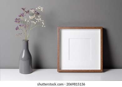 Square Wooden Frame Mockup For Artwork, Photo, Print And Painting Presentation With Dry Flowers Over Grey Wall.