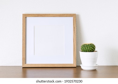 Square Wooden Photo Frame And Cactus On The Table.