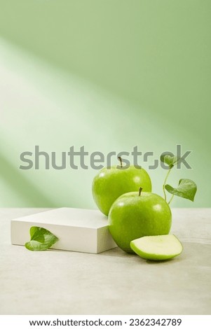 Square-shaped podium with vacant space arranged with organic green apples. Eating Green Apple (Malus domestica) has been shown to improve heart health