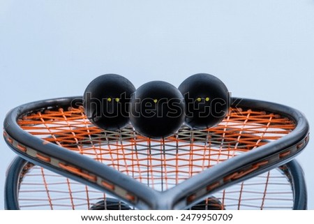 Squash balls on the background of a squash racket with a mirror image. Squash equipment for game.