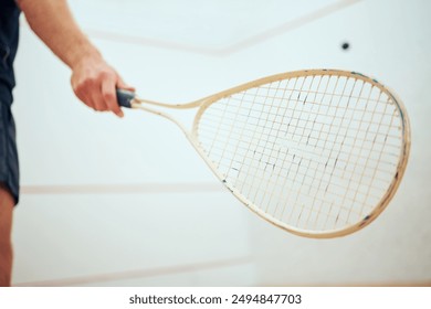 Squash, closeup and man with racket, hand and sports for stress relief, fitness and exercise. Person, training and player in wellness center, game and competition with practice, workout and active