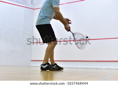 Squash player in action reaching on squash court. Squash Players on Tournament. Sports equipment and sportswear for playing squash. 