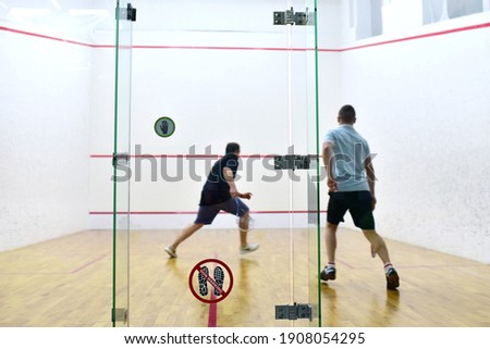 Squash player in action reaching on squash court. Squash Players on Tournament. Sports equipment and sportswear for playing squash.  Soft focus