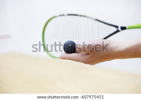 squash racket and ball in man's hands. Racquetball equipment. Photo with selective focus