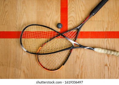 Squash rackets and ball on court floor, top view - Shutterstock ID 1619336497