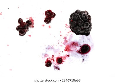 Squashed exploding and crushed blackberries fruit berries splattered on a white background with juice