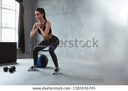 Squats. Sports Woman In Fashion Clothes Squatting With Band