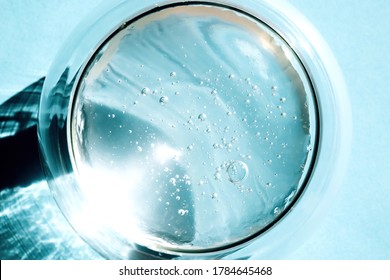 Squeezed Cosmetic Clear Cream-gel Texture. Close Up Photo Of Transparent Aloe Vera Gel With Bubbles In A Glass Bowl On Blue Background. Skincare, Healthy Product.